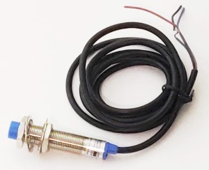 Inductive proximity sensor with nuts and lock washers on the sensor shaft