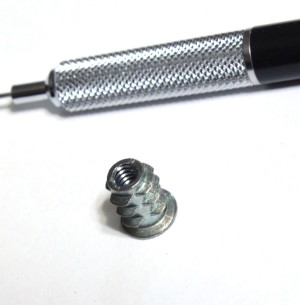 Number Eight insert nut shown with mechanical pencil for scale 