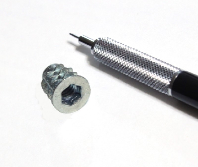 one quarter inch Insert Nut shown with mechanical pencil for scale