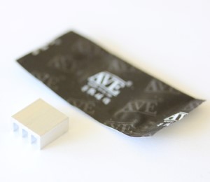 The bottom side of the small aluminum heat sink with a packet of thermal compound